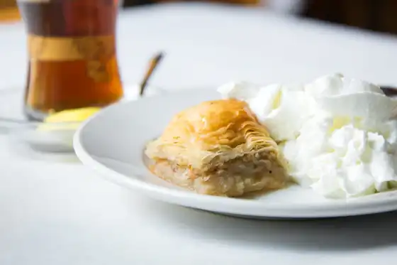 Homemade Baklava with a drizzle of honey and whipped cream, perfect with a glass of Turkish tea.