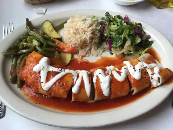 Beyti Kebab, Seasoned ground lamb and beef patties mixed with parsley, onions, garlic and grilled on flat skewers, rolled with lavash bread and served with tomato sauce