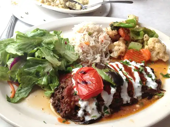 Iskender, slices of Doner on grilled bread cubes, covered with tomato sauce and served with yogurt on the side